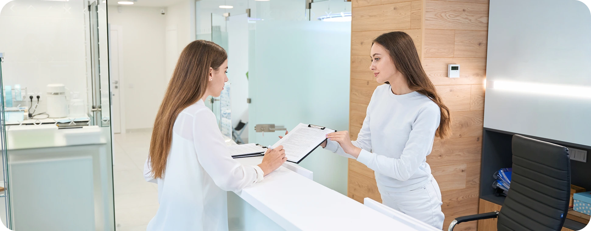 Two women at doctors office front desk